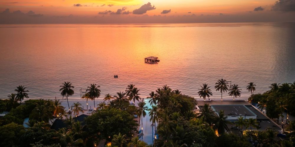 Sunset view of the Coralarium at Sirru Fen Fushi, Maldives, surrounded by calm ocean and palm-fringed beachfront
